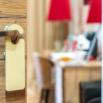 Stylish hotel room door handle with a blank sign in a well-decorated interior.